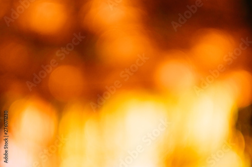 Red and yellow bokeh lights. Defocused lens flare. Autumn leaves design. Abstract art background.