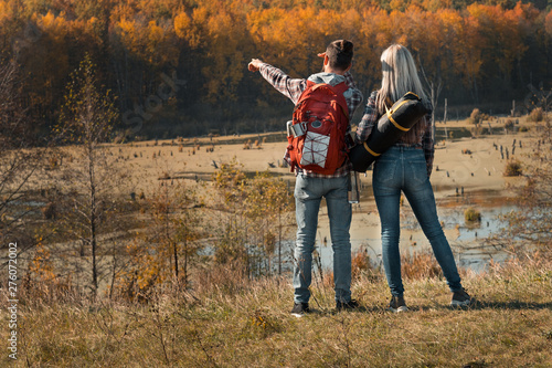 Hiking travel. Back view of couple looking at forest and swamp. Fall nature landscape background.
