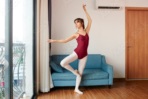 Transgender ballet dancer in tights and leotard practicing new movement for performance