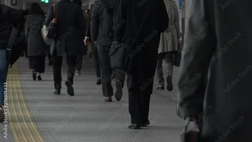 TOKYO, JAPAN - CIRCA APRIL 2019 : Scenery of RUSH HOUR at SHINJUKU.  Back shot of unidentified crowd of people going back to home from work at night.
