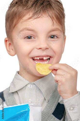 Close up portrait of cheerful child with pleasure eating potato chips  isolated on white background. Cute little boy is eating chips and smiling.