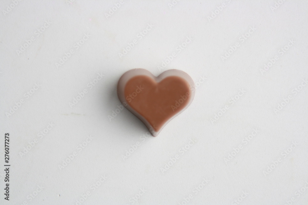 Chocolate bonbon with heart shape on white background