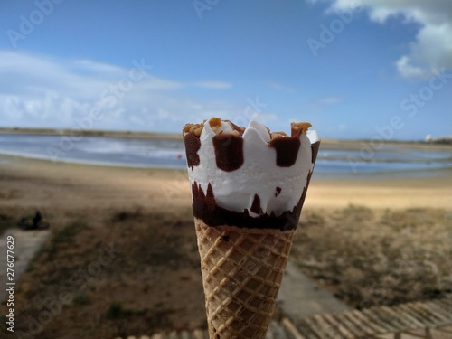  Primer plano de helado de vainilla y caramelo con fondo de mar en España