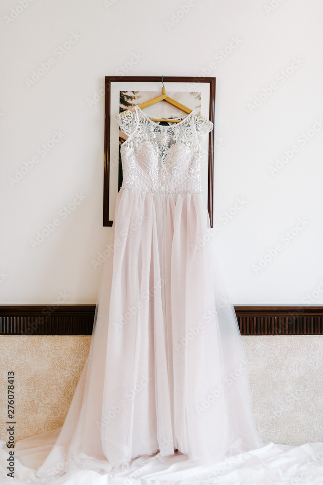 White wedding dress hanging in the bedroom. White bride dress White wedding dress hanging in the bedroom. White bride dress