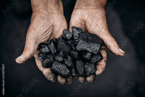 Miner holds coal palm. Concept mining. Top view.