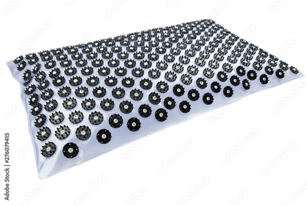 Acupuncture orthopedic massage mat with needles and spikes for feet and body isolated on white background. Alternative medicine, health care, recreation and muscle relaxation concept. Acupuncture orthopedic massage mat with needles and spikes for feet and body isolated on white background. Alternative medicine, health care, recreation and muscle relaxation concept.