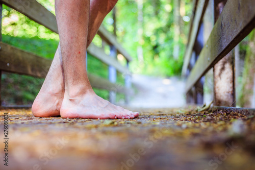 Forest adventure: Closeup of barefoot male feet on a wooden bridge in the woodland © Patrick Daxenbichler