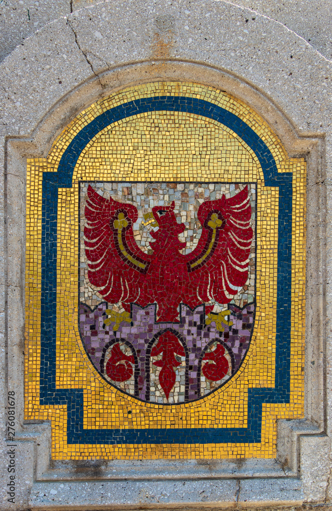 Stone Crest, Emblem, Flag of City Meran on a bridge in the central district. Merano. Province Bolzano, South Tyrol, Italy. Europe. Stone Crest, Emblem, Flag of City Meran on a bridge in the central district. Merano. Province Bolzano, South Tyrol, Italy. Europe.