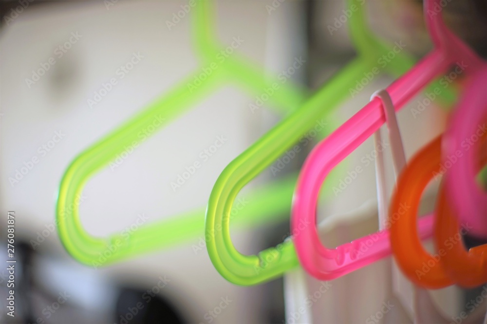 A set of colorful plastic hangers hanging on the rack A set of colorful plastic hangers hanging on the rack