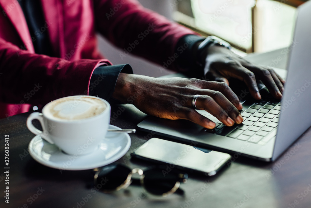 Close up photo. Businessman hand using laptop, working online at coffee shop in morning light. Close up photo. Businessman hand using laptop, working online at coffee shop in morning light.