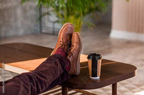 Close up of a man holding his legs on a table