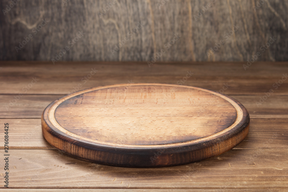 pizza cutting board at rustic wooden table in front - obrazy, fototapety, plakaty 