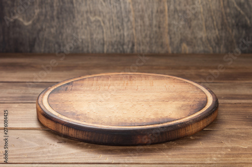 Photo pizza cutting board at rustic wooden table in front