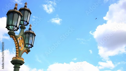 Close-Up Time Lapse Of Street Lamp On Westminster Bridge And The Helicopter Over The London City photo