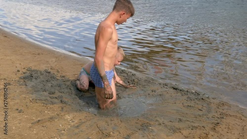 boy playing with sand on the beach