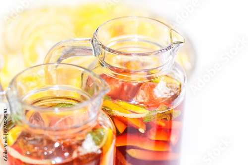 Two pither jugs with traditional British summer Pimms cocktail punch with lemonade, strawberries, cucumber, orange and mint isolated. Garden party or catering concept with copy space
