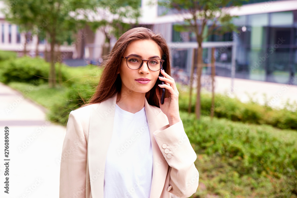 Young businesswoman making a call while walking on the street Young businesswoman making a call while walking on the street