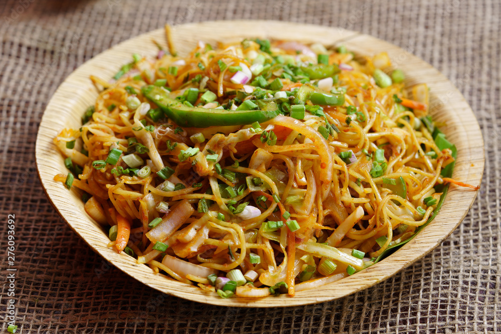 Schezwan Noodles or vegetable Hakka Noodles or chow mein is a popular Indo-Chinese recipes, served in a bowl or plate 