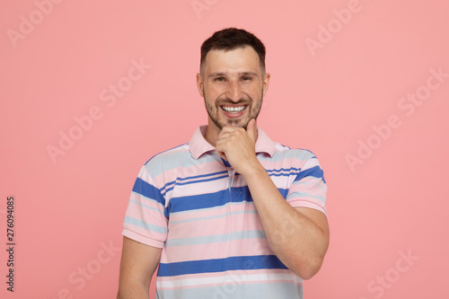 Handsome man over pink background laughing.