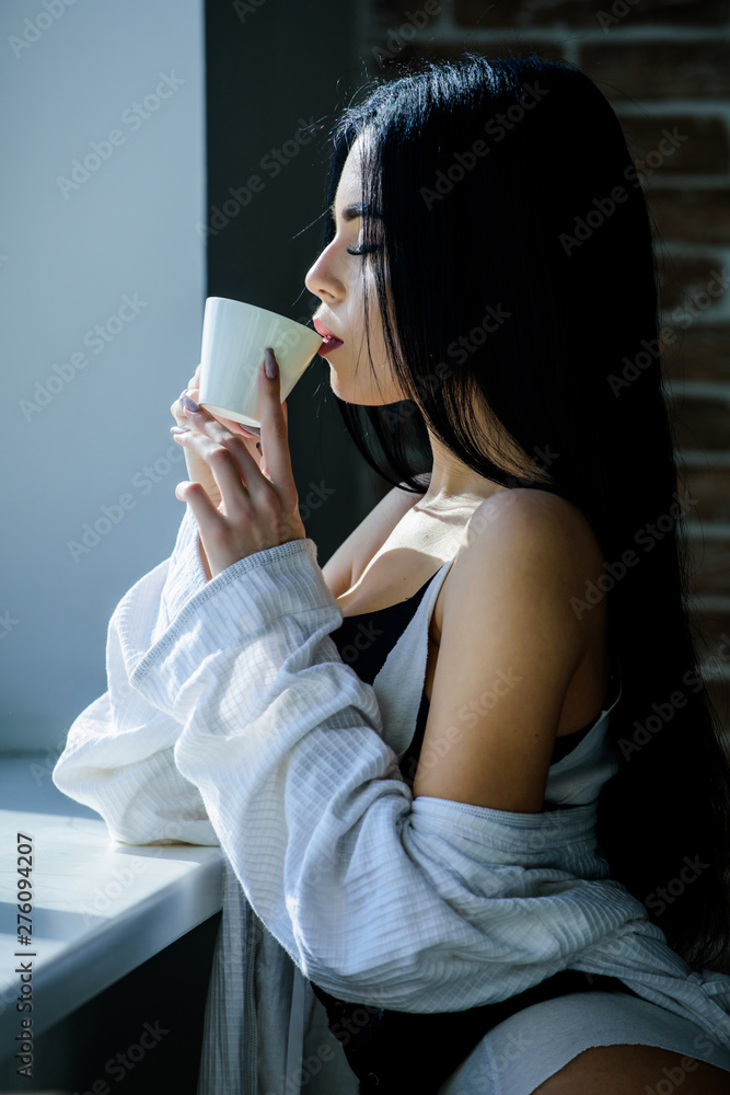 The best coffee for her daily routine. Sensual girl drinking her favorite  morning coffee. Pretty woman drinking fresh hot coffee at window. Sexy girl  holding ceramic coffee cup Stock Photo | Adobe