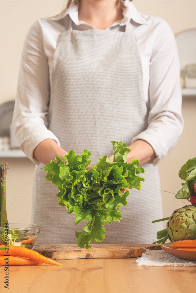 The chef is holding a green lettuce in the form of a heart. The concept of losing healthy and wholesome food, detox, vegan eating, diet, cooking.comfort food, healthy diet, clean eating. Close-up The chef is holding a green lettuce in the form of a heart. The concept of losing healthy and wholesome food, detox, vegan eating, diet, cooking.comfort food, healthy diet, clean eating. Close-up