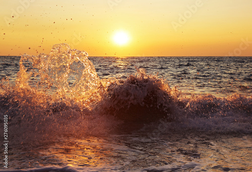 sunset scenery of a beach at Paxos Ionian islands Greece - waves splash hitting the rocks photo