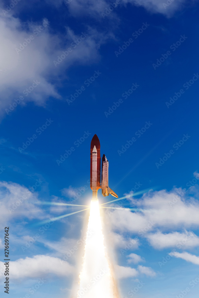 Naklejka premium Blue cloudy sky and rocket. Launching space ship into cosmos. Elements of this image furnished by NASA.
