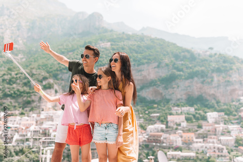 Parents and kids taking selfie photo background Positano town in Itali on Amalfi coast
