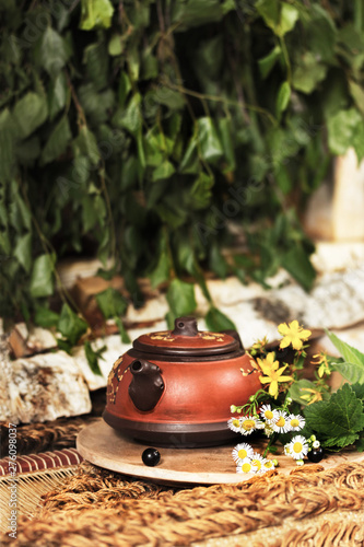 small kettle with fresh fragrant tea of ​​herbs and flowers