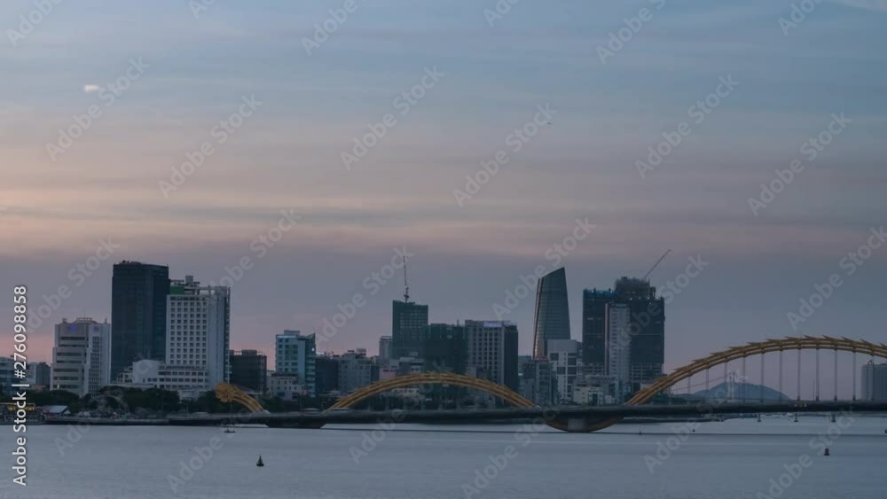 City Time Lapse of Modern Urban Skyline - A Day to Night Transition with Neon Lights, Dragon Bridge and Boats on River in Vietnam Asia. City Time Lapse of Modern Urban Skyline - A Day to Night Transition with Neon Lights, Dragon Bridge and Boats on River in Vietnam Asia.