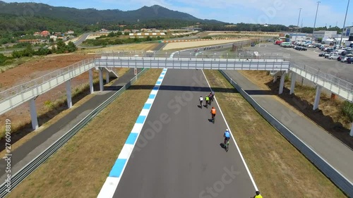 Aerial, drone shot, over cyclists, racing with bikes, at a 24h cycling competition, on Autodromo do Estoril Circuit, on a sunny day, near Lisbon, Portugal photo