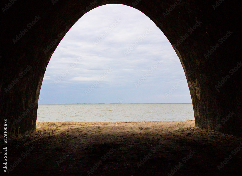 View of the gray-blue sky over the sea from the tunnel.