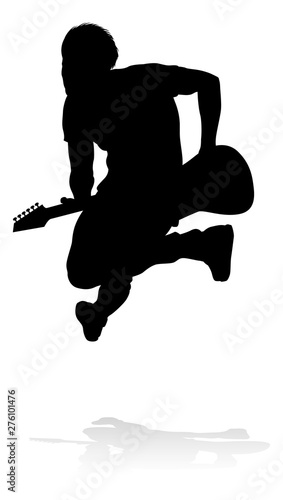 A guitarist musician in detailed silhouette playing his guitar musical instrument.