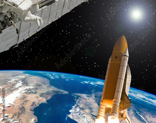 Space station and rocket above earth. The elements of this image furnished by...