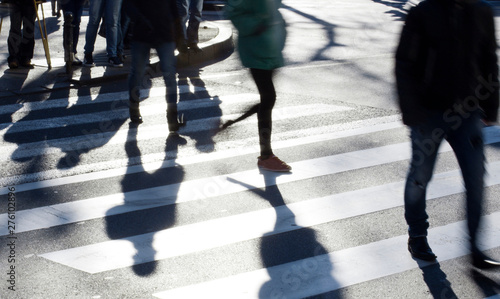 Blurry zebra crossing with pedestrians making long shadows