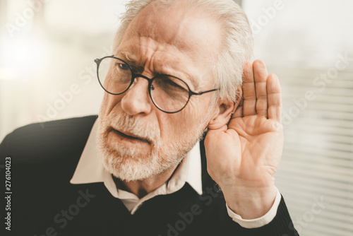 Senior man with hearing problems photo