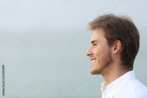 Side view portrait of a happy man on the beach