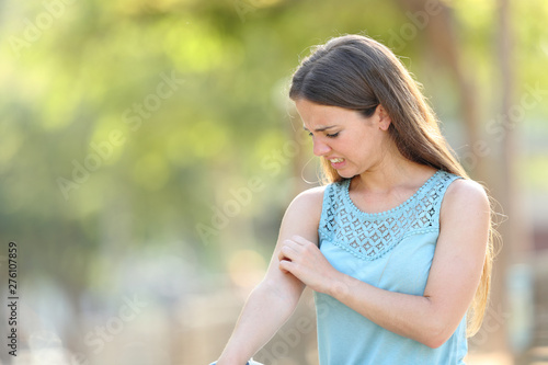Woman scratching arm because it stings photo