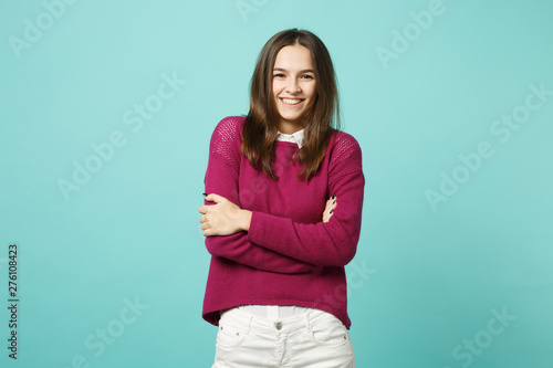 Young brunette woman girl in casual clothes posing isolated on blue green turquoise wall background studio portrait. People sincere emotions lifestyle concept. Mock up copy space. Looking camera smile