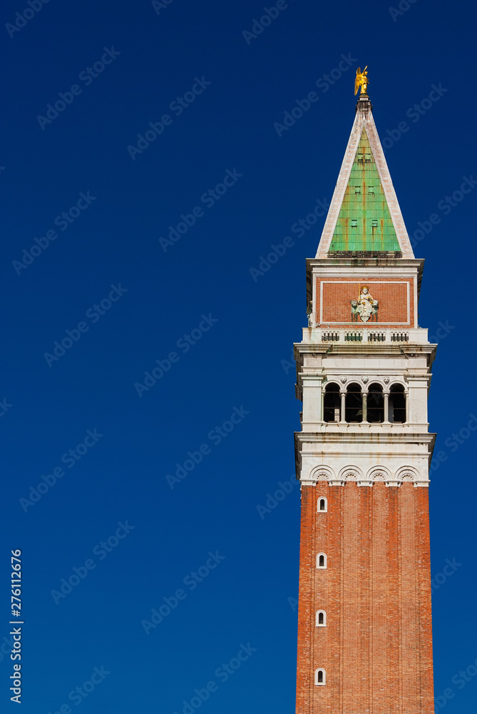 Saint Mark bell tower in the center of Venice with golden angel statue at the top (with copy space)
