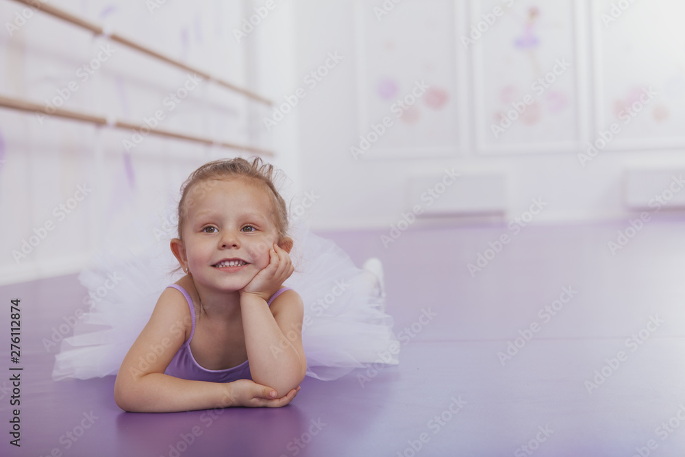 Charming little ballerina lying on the floor, looking away dreamily. Adorable little girl dreaming of becoming ballerina. Aspirations, achievement concept Charming little ballerina lying on the floor, looking away dreamily. Adorable little girl dreaming of becoming ballerina. Aspirations, achievement concept