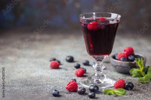 Berry drink with fresh blueberries and raspberries, berry ice lemonade in a glass