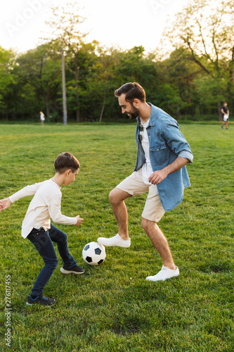 Two cheerful brothers playing football on the lawn © Drobot Dean