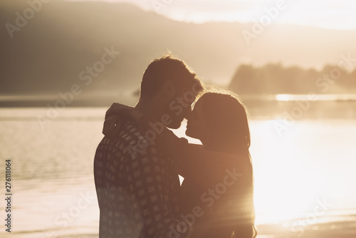 Romantic loving couple kissing at sunset