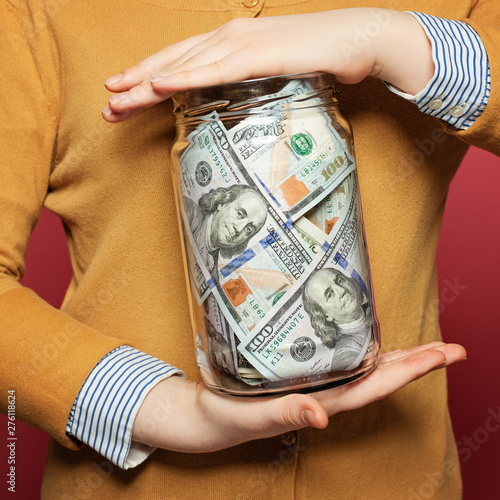 Cash us dollars in jar on colorful bright background. Saving money concept photo