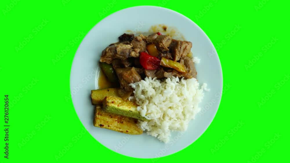 Food rotates on a plate. View from above. Healthy food concept. Baked meat with vegetables and rice. Slices of zucchini, eggplant and sweet pepper. Food rotates on a plate. View from above. Healthy food concept. Baked meat with vegetables and rice. Slices of zucchini, eggplant and sweet pepper.