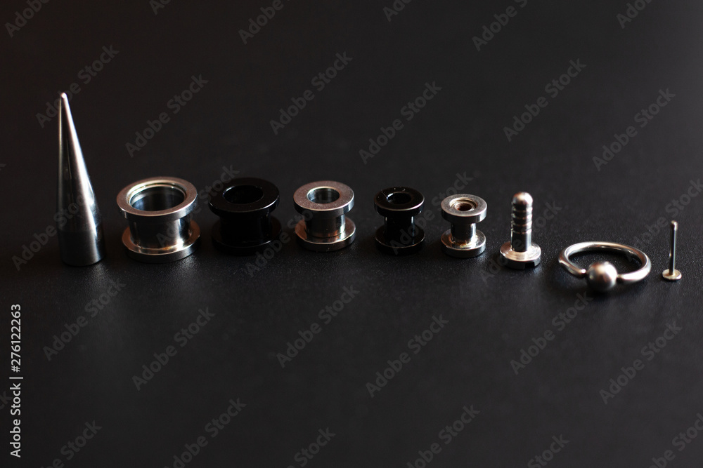 set of accessories for piercing on a dark background set of accessories for piercing on a dark background