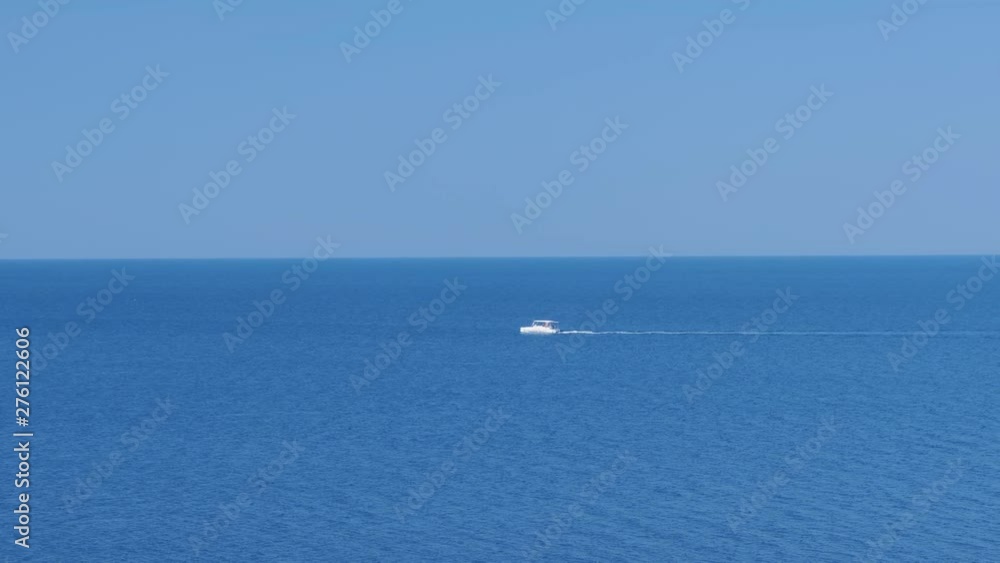 White motor boat sailing on the sea at summer sunny day, side view. White motor boat sailing on the sea at summer sunny day, side view.