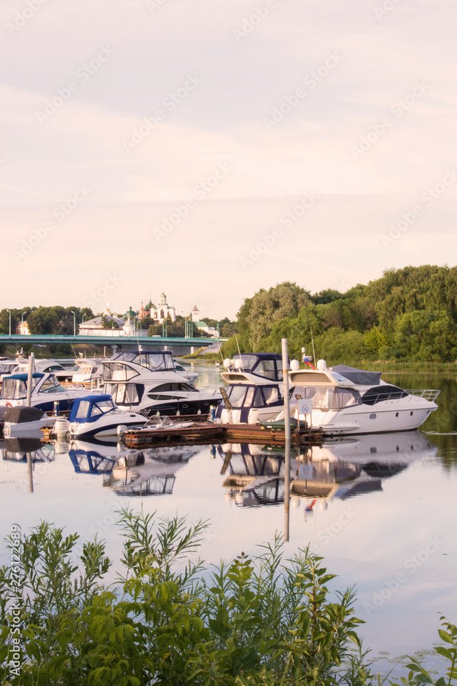 Fototapeta premium Yaroslavl. View of the Parking boats on the Kotorosl river and the Spaso-Preobrazhensky monastery. Summer evening before sunset