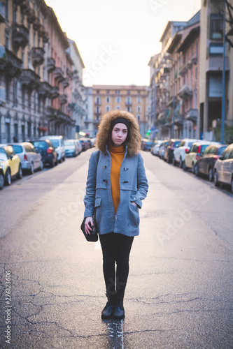 young woman standing in the middle of the street